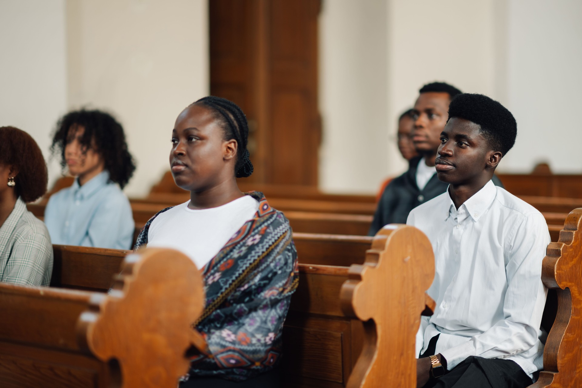 Group of people sitting in church pew listening to sermon