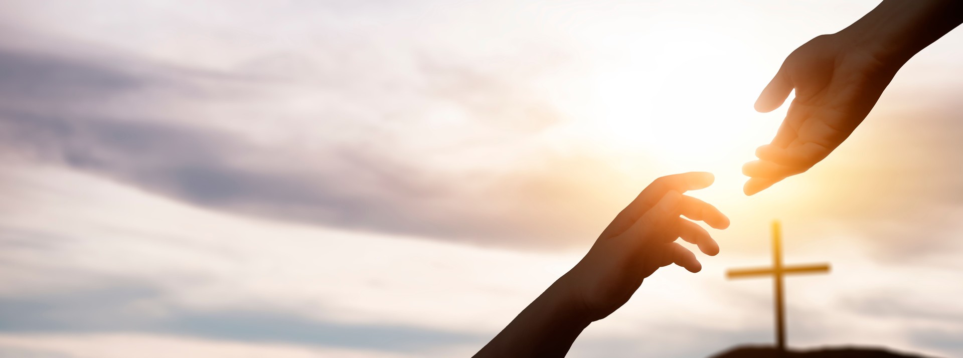 the hand of god helping and giving hope, in a background with the cross of christ